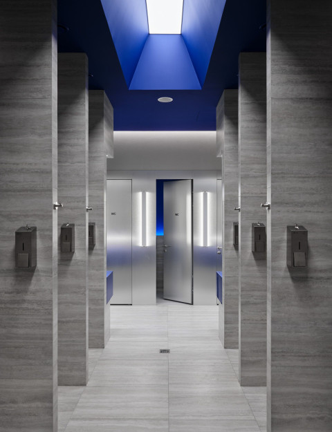 Vertical stairs detail at Gate-X Fitness Club with concrete surfaces and blue light