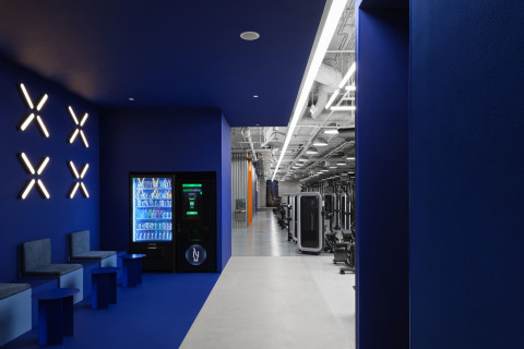 Wide training area at Gate-X Fitness Club with exercise machines and cinematic lighting