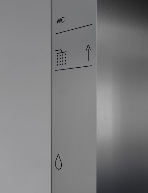 Vertical interior detail showing concrete, dark panels and blue accents at Gate-X Fitness Club