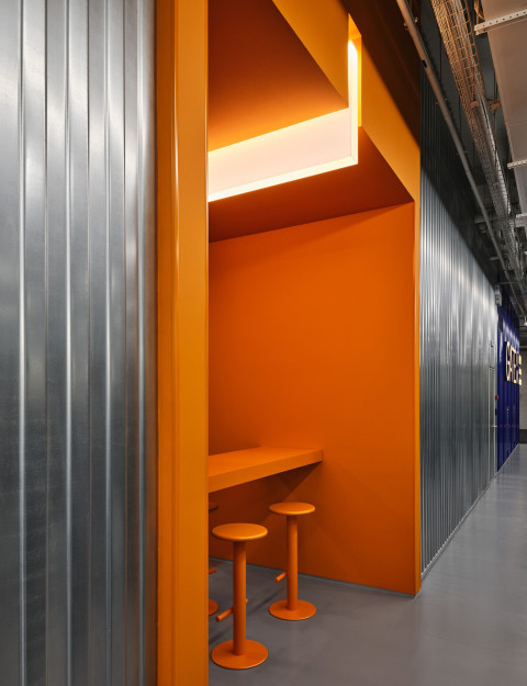 Vertical architectural detail with blue ceiling and concrete surfaces at Gate-X Fitness Club