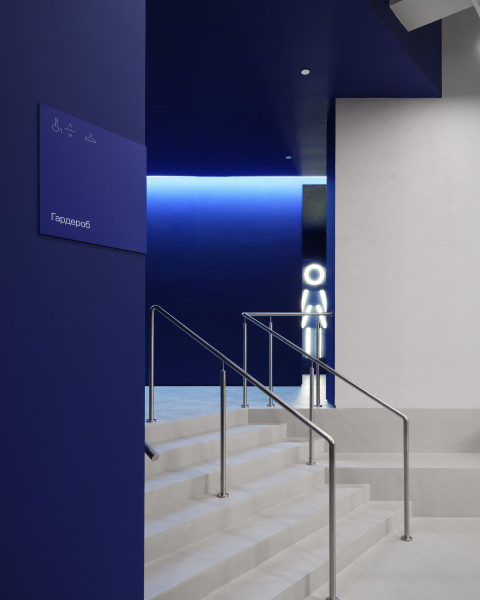 Vertical interior view of gym equipment and dark architectural finishes at Gate-X Fitness Club