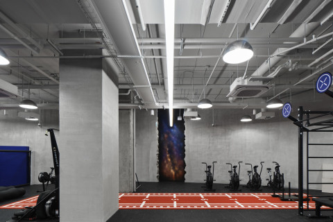Wide changing room area at Gate-X Fitness Club with concrete textures and cool lighting