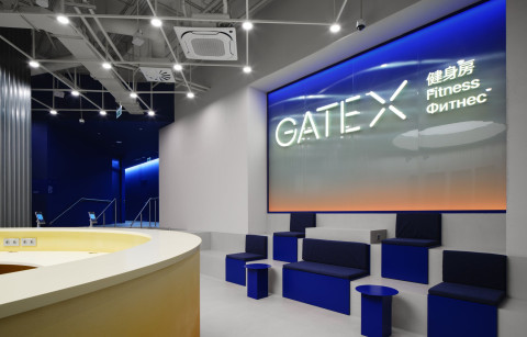 Wide view of the Gate-X Fitness Club training area with dark materials and linear lighting