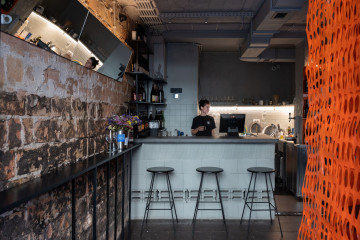 Proces Wine bar main hall with building block counter, bench seating and orange lighting