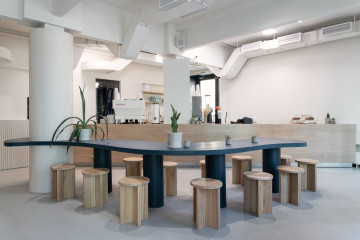 The Waterfront Cafe interior with ocean blue wall, sand-toned seating and curved central dining table
