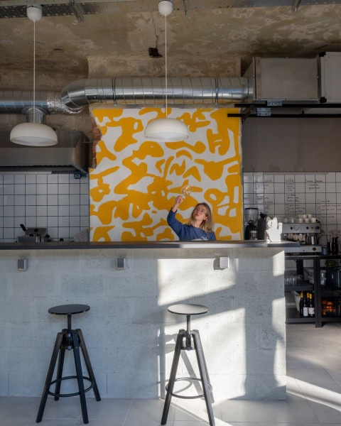 Blue and yellow wall composition with red seating inside TT-Eatery