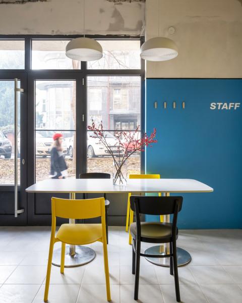 Window seating area with red chairs and tables at TT-Eatery